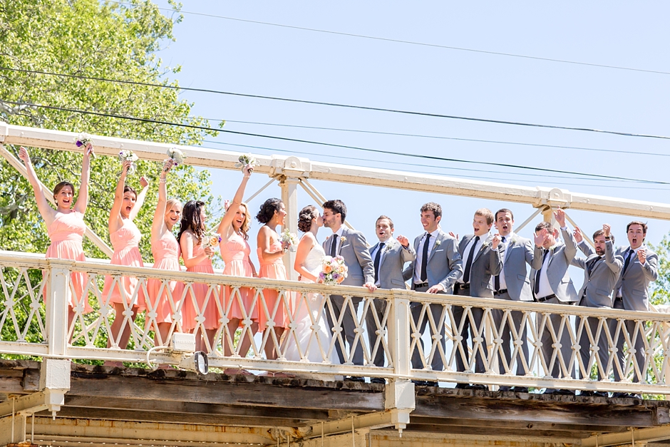 Bridal party cheering on bridge