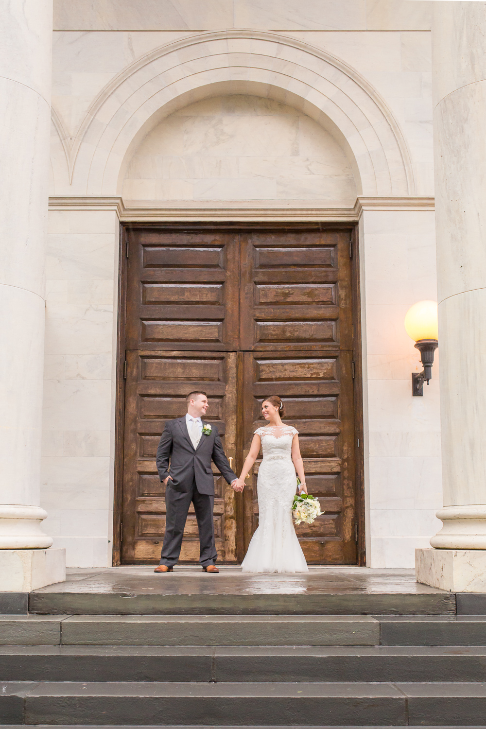 Couple posing under covered area on a rainy day wedding