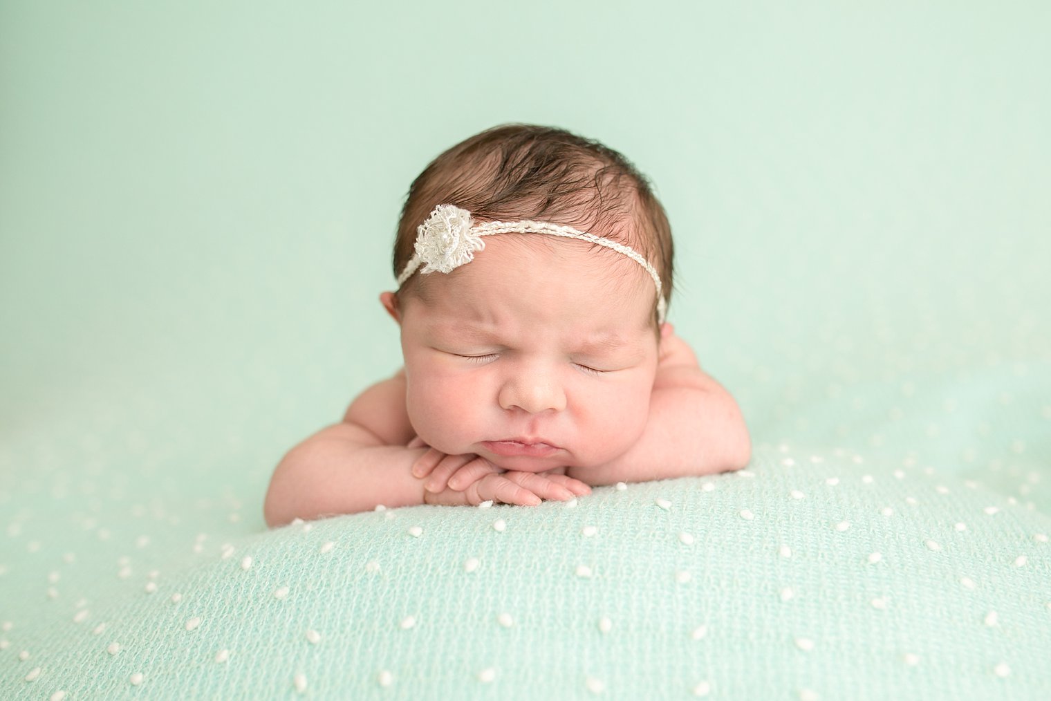 Chin on hands newborn pose