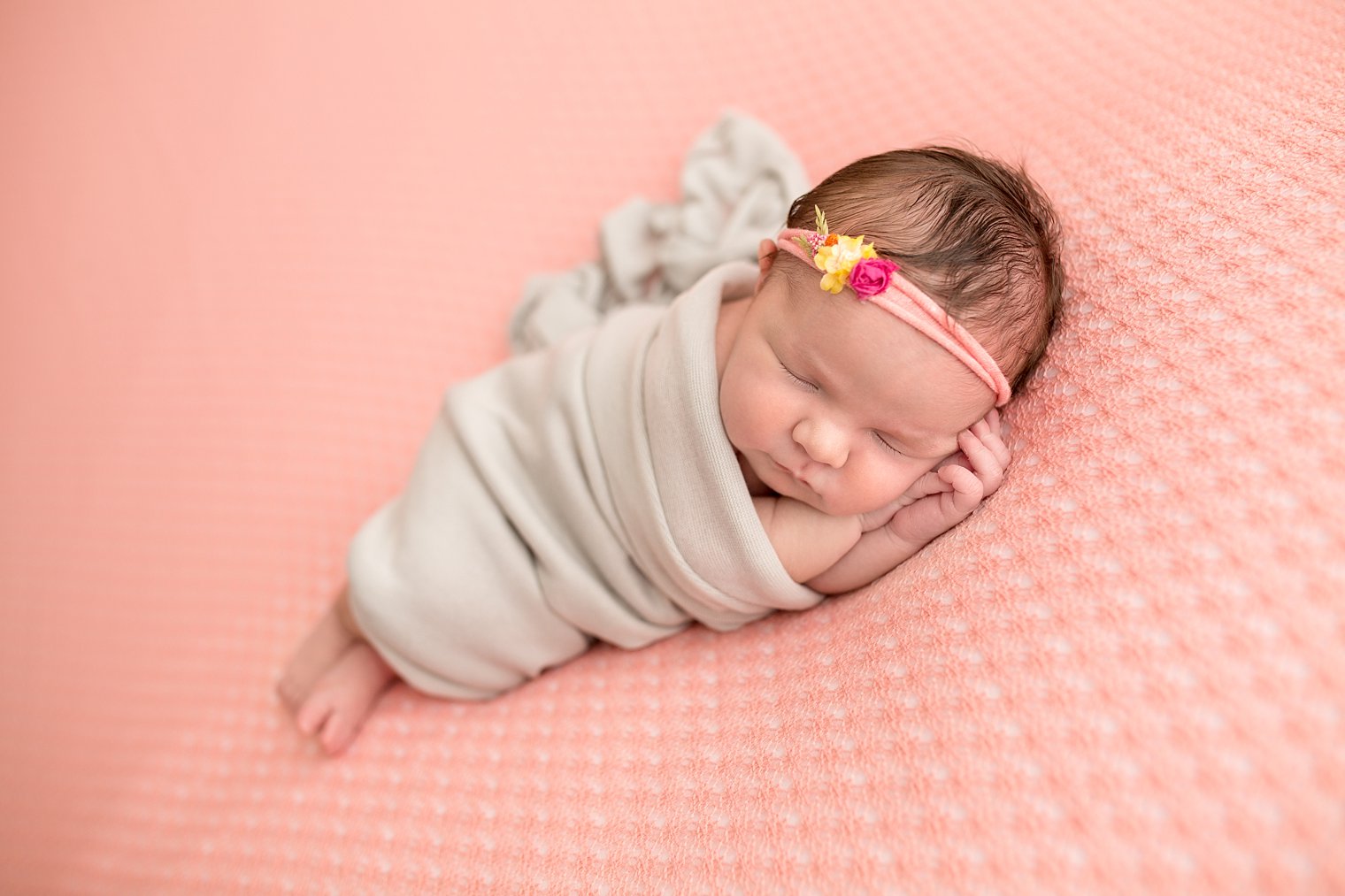 Photo of newborn girl in coral and gray