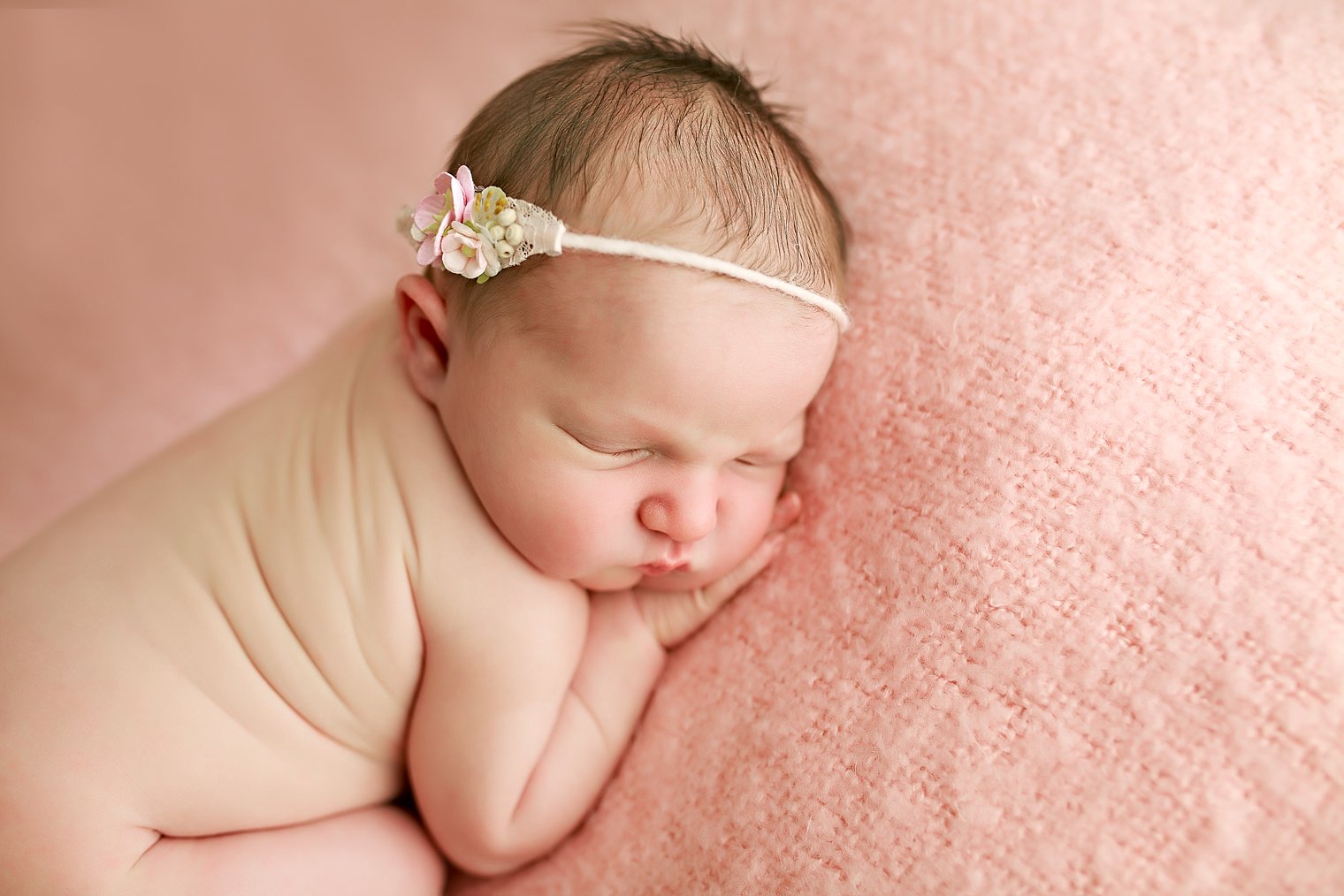 Photo of newborn baby girl on pink blanket