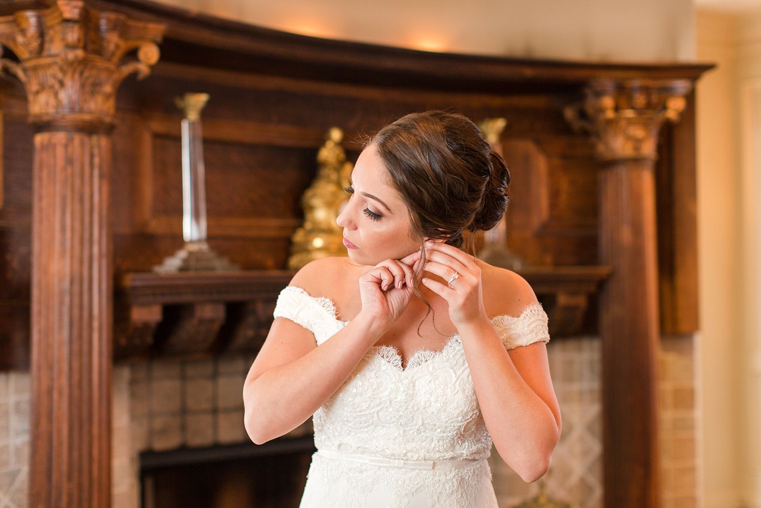 Photo of bride putting on earrings