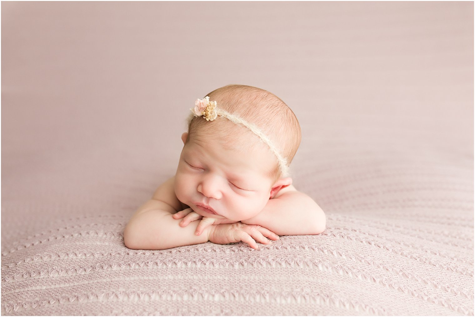 Newborn in chin on hands pose
