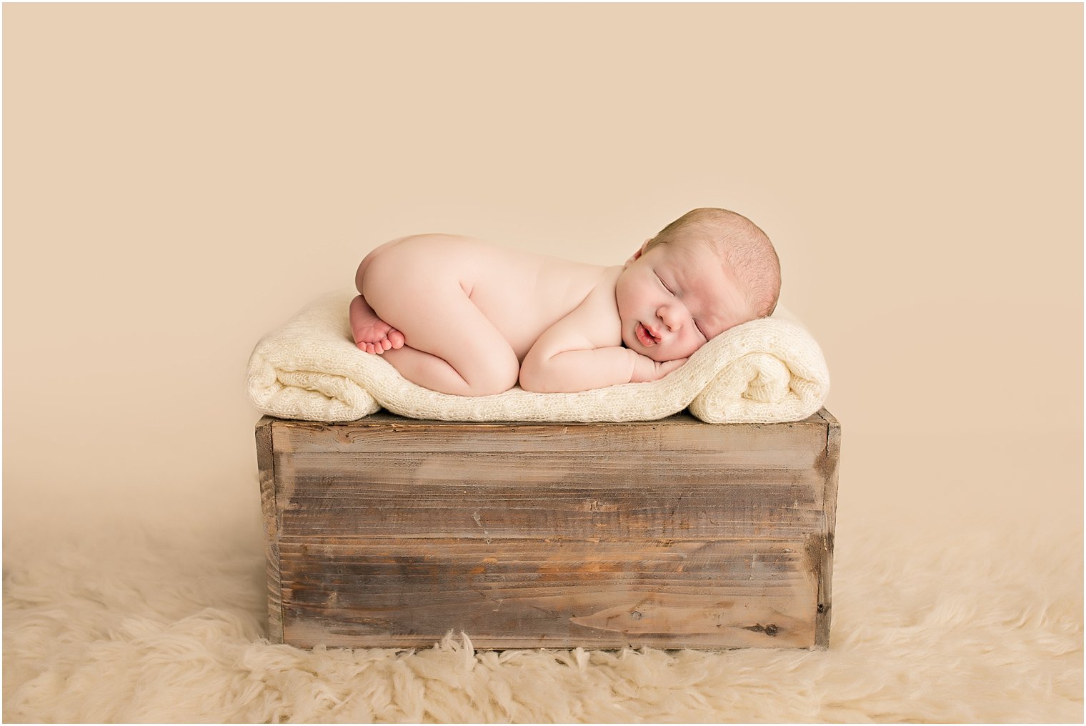 Newborn boy on crate