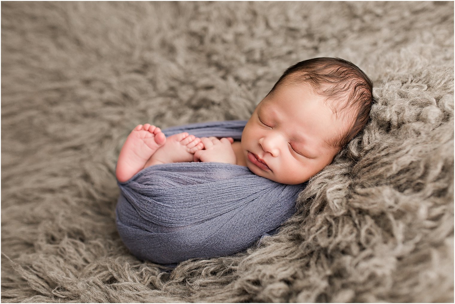 Baby boy in blue wrap and flokati fur