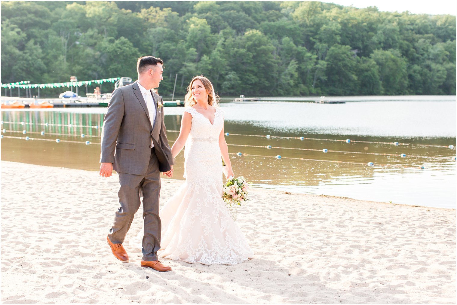 Bride and groom walking on beach at Lake Valhalla Club