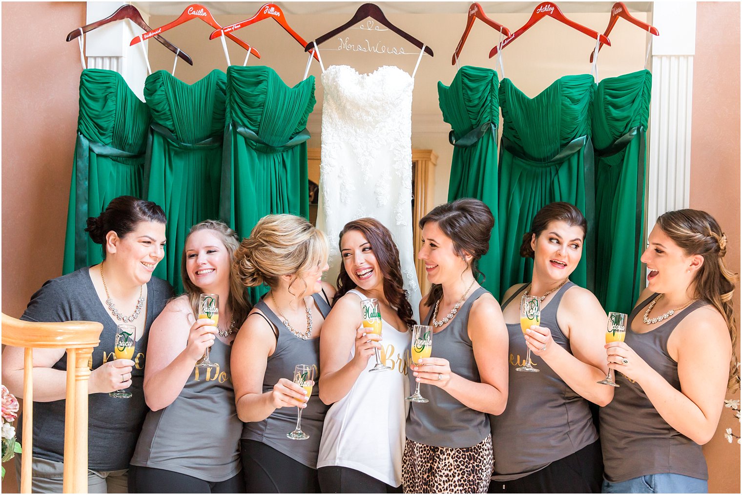 Bridesmaids drinking mimosas in gray tank tops