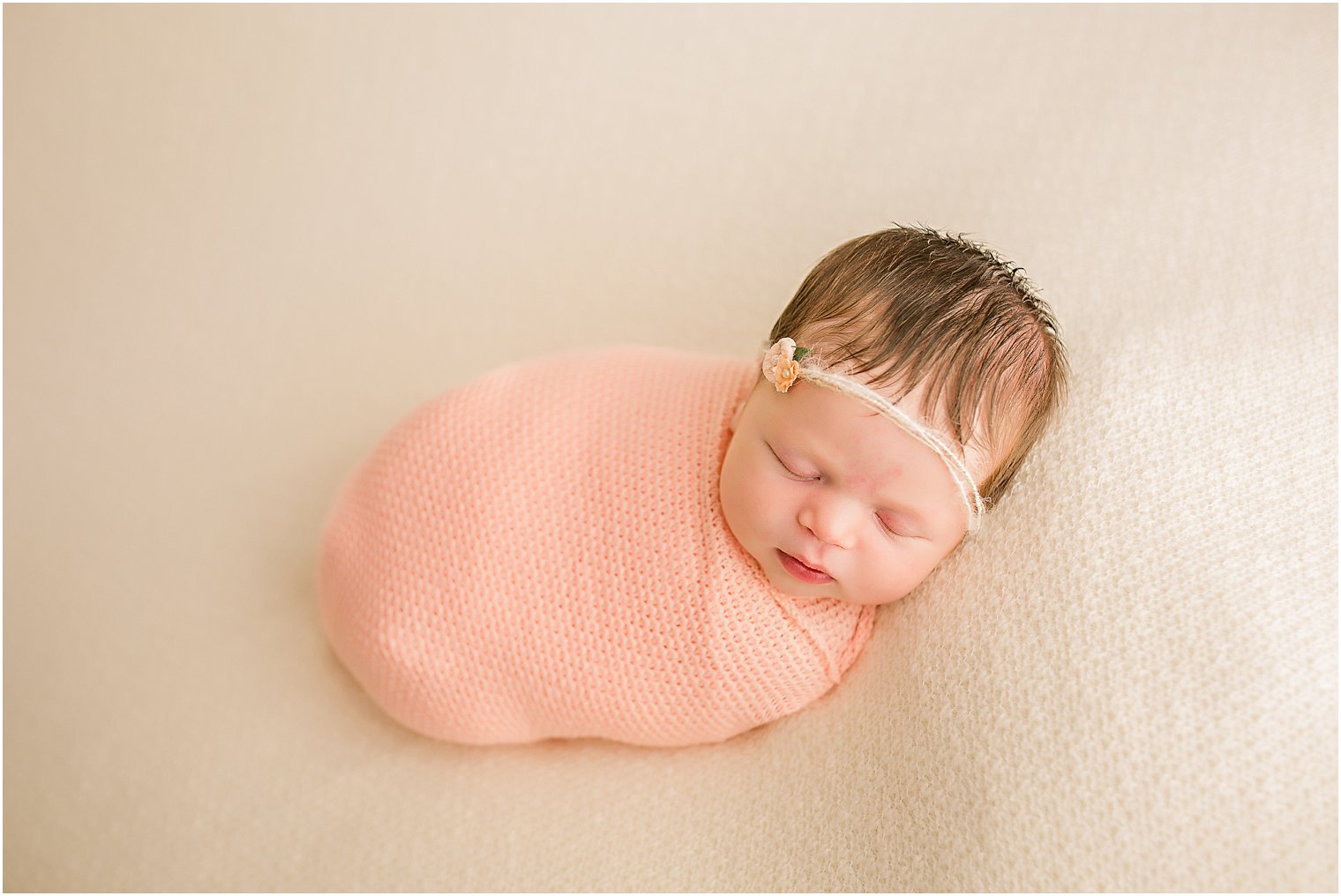 Baby wrapped up in coral pink