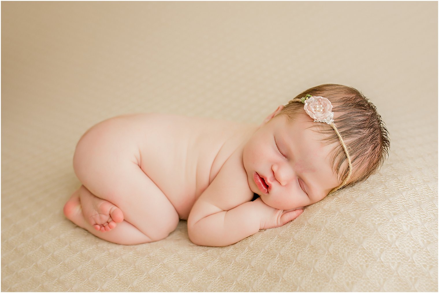 Newborn baby in beige and coral pink