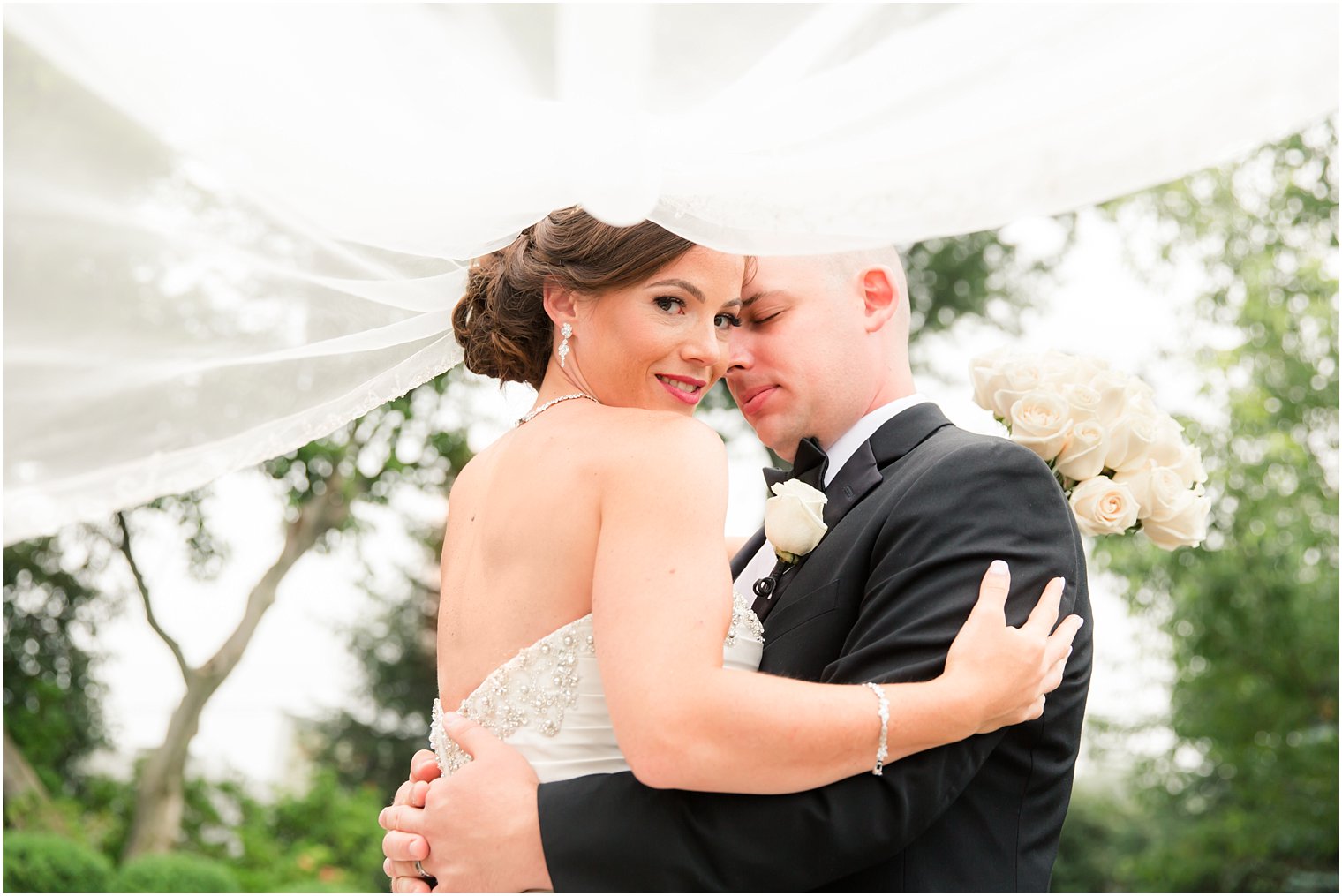 Bride and groom under veil photo