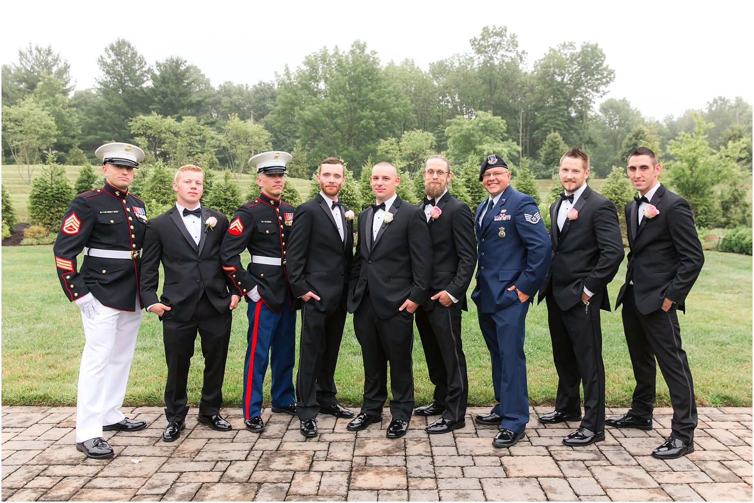 Groomsmen in black tuxedos and military uniforms