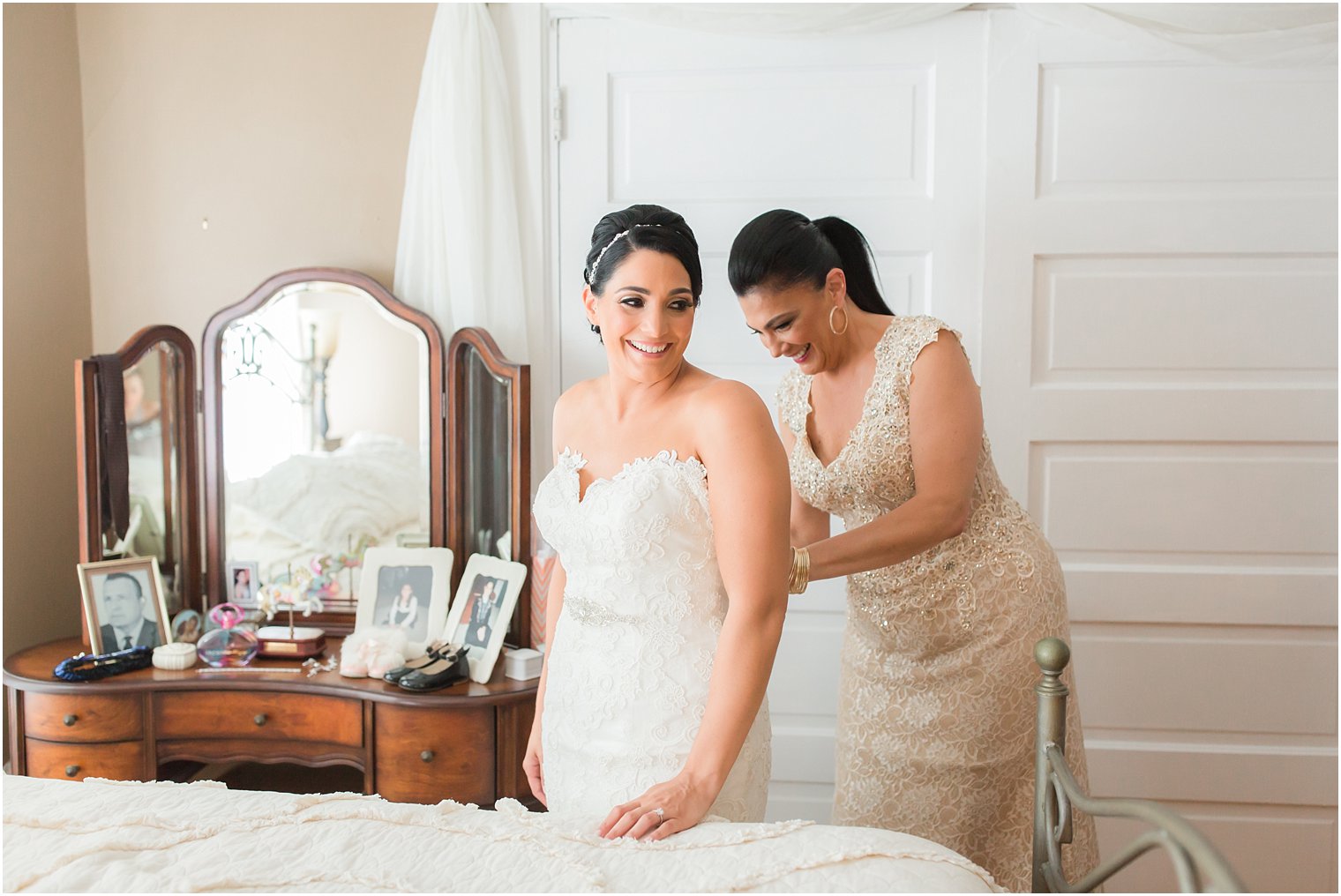 Mom helping bride into her dress
