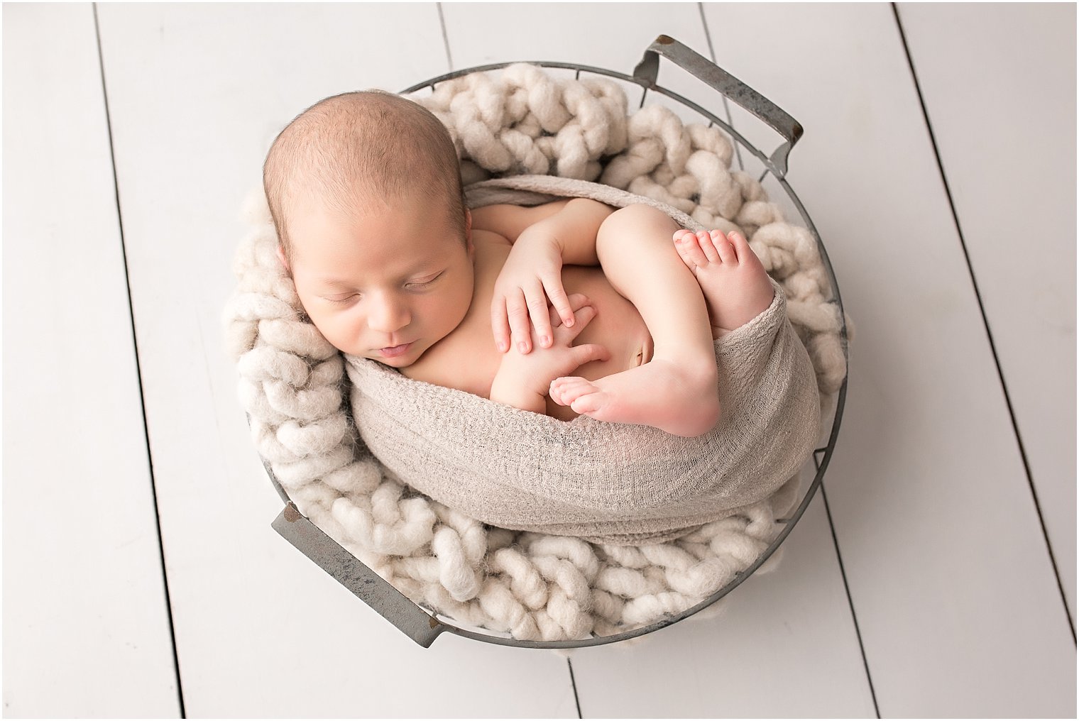 Newborn boy in a basket pose