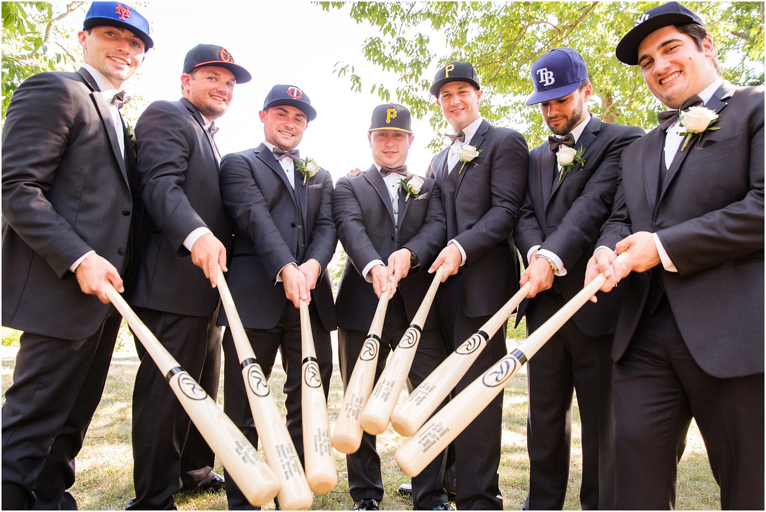 Groomsmen with baseball caps and bats