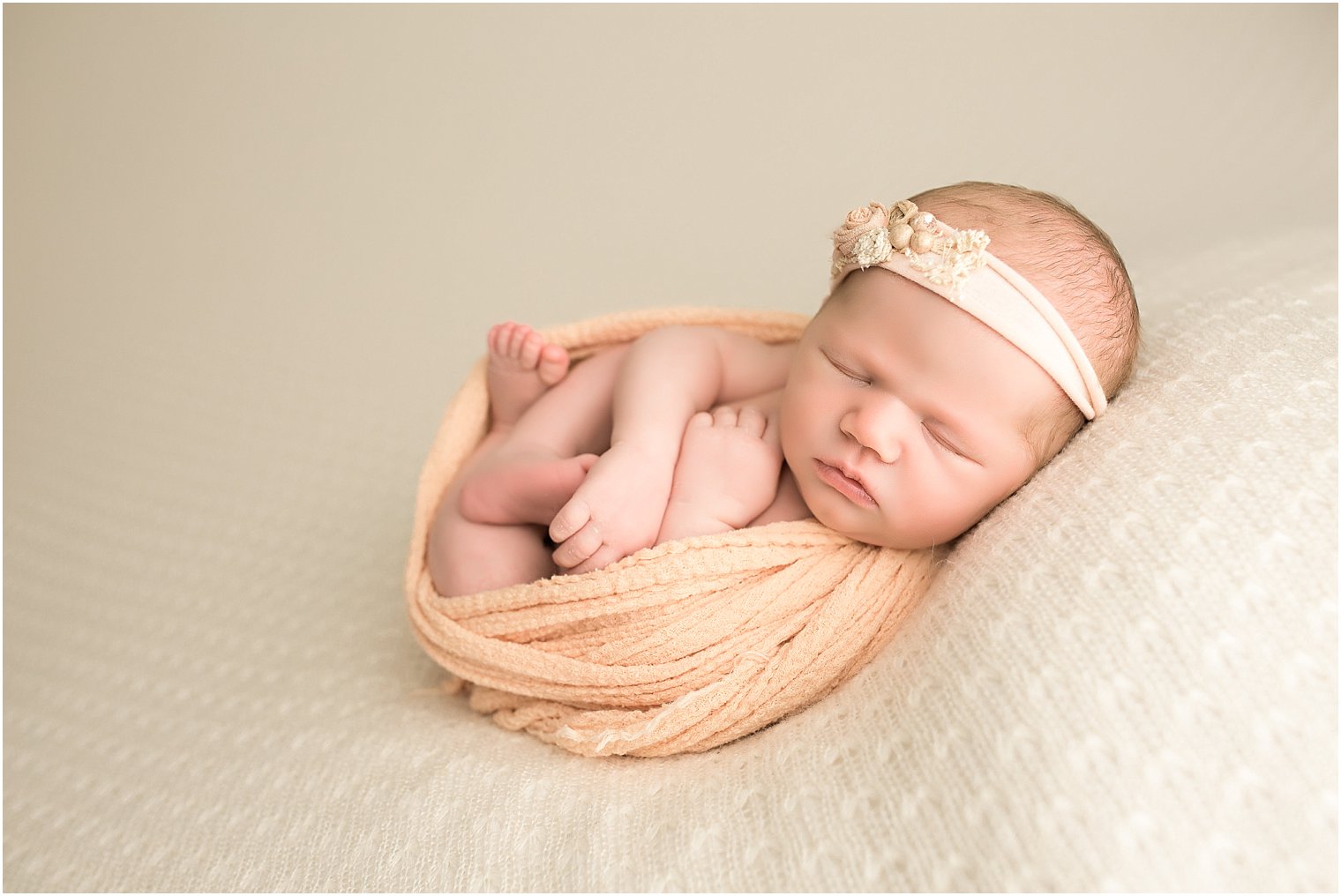 Newborn girl in cream and peach