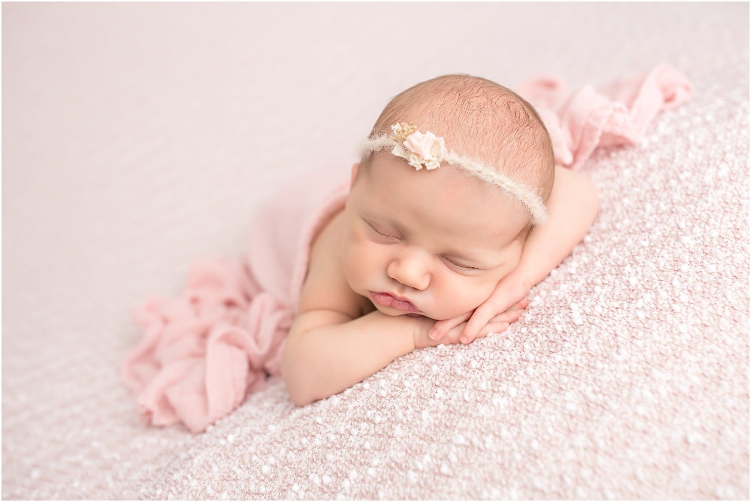 Newborn on pink blanket