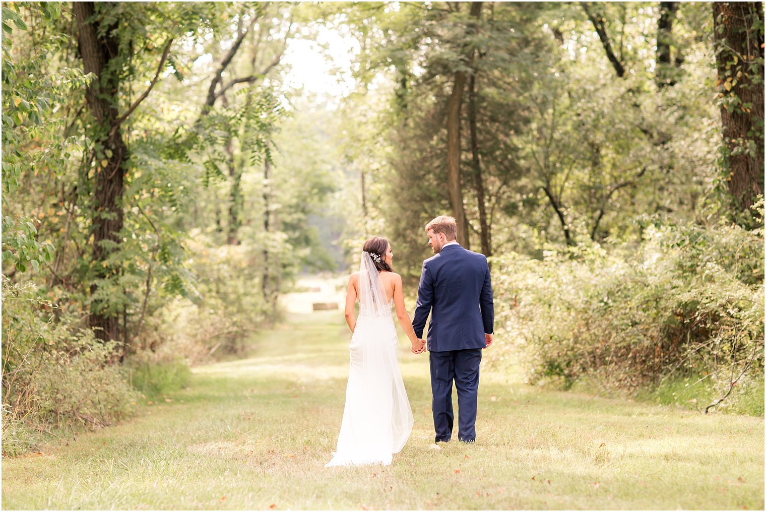 Bride and groom walking in field