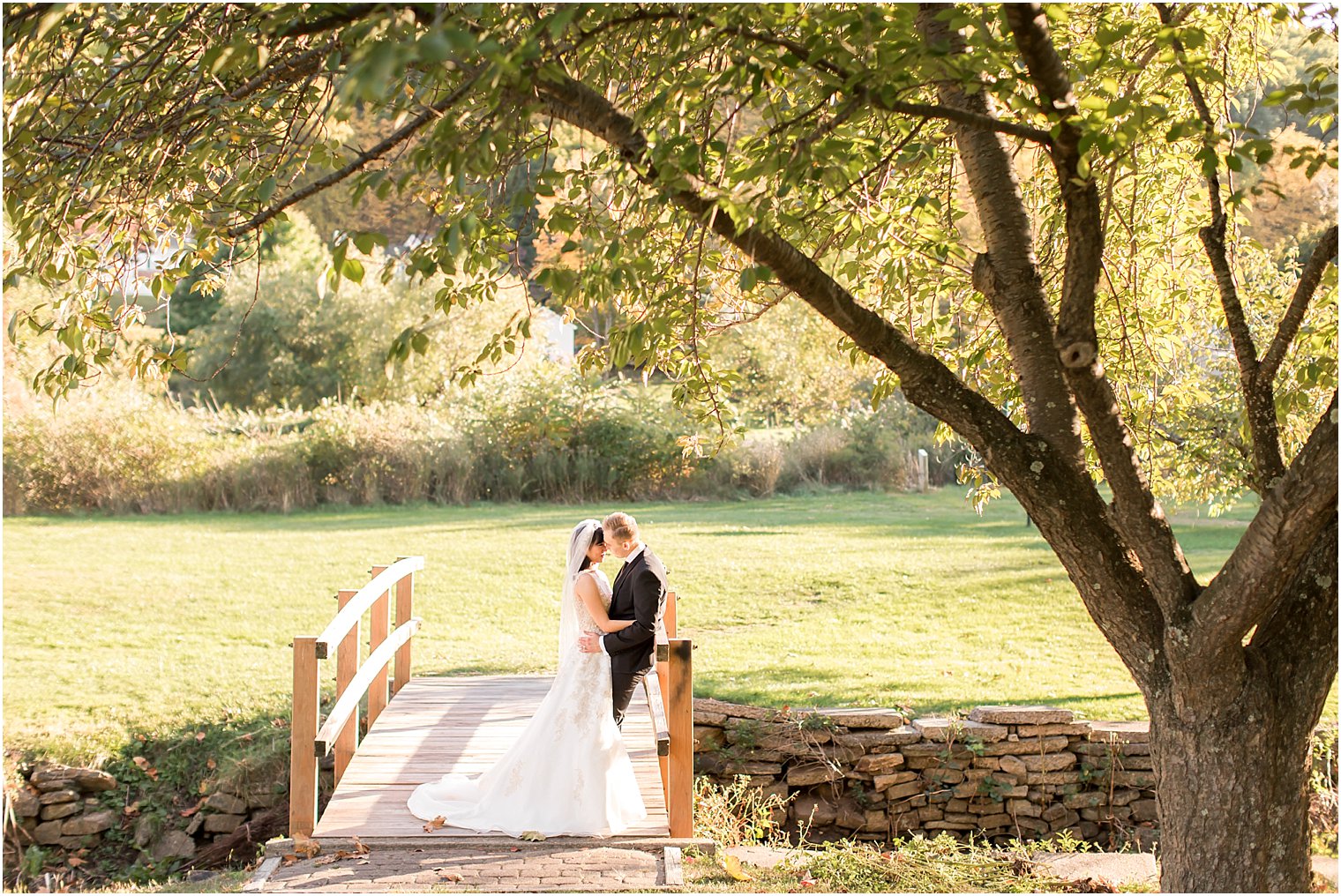 Bride and groom kissing on a bridge