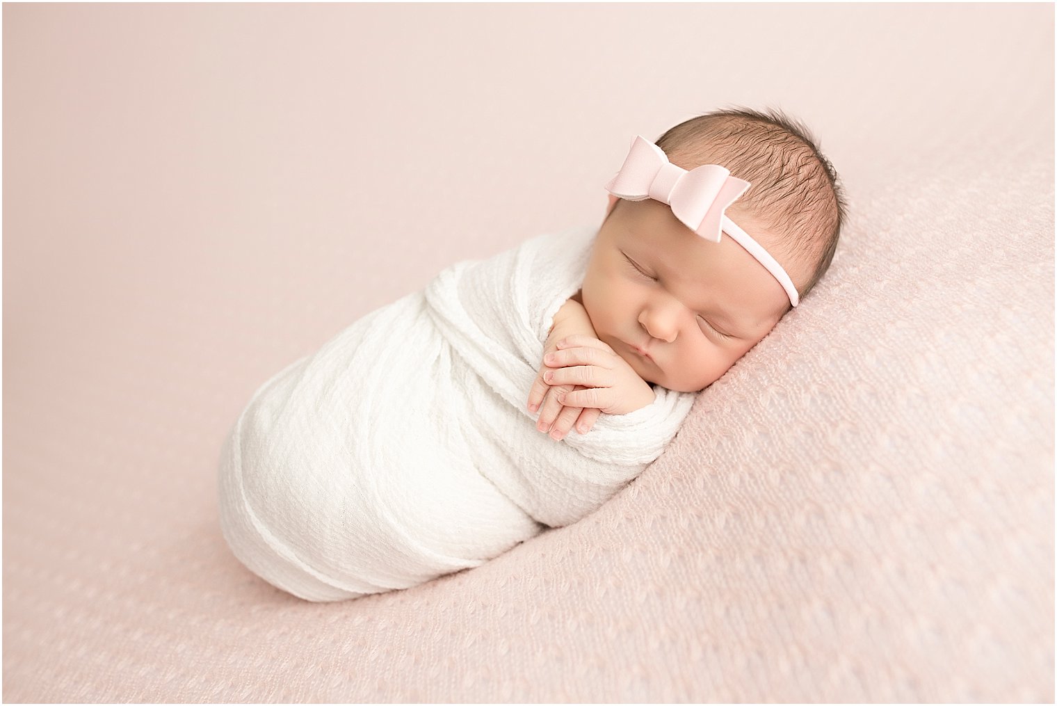 Newborn baby girl in pink and white