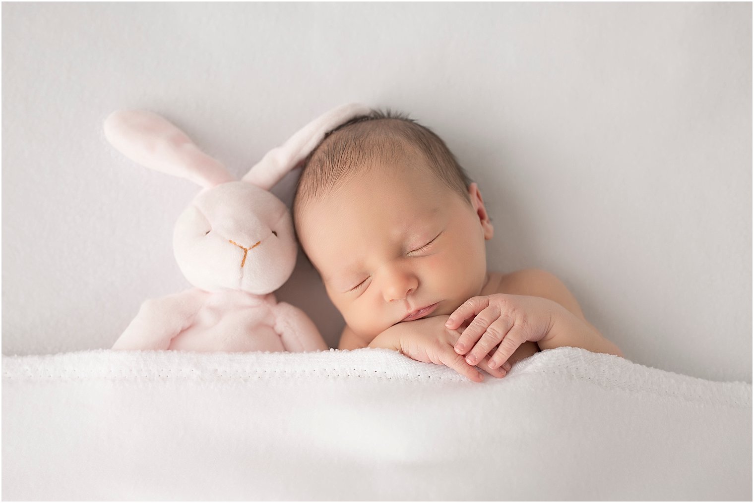 Newborn girl with pink bunny