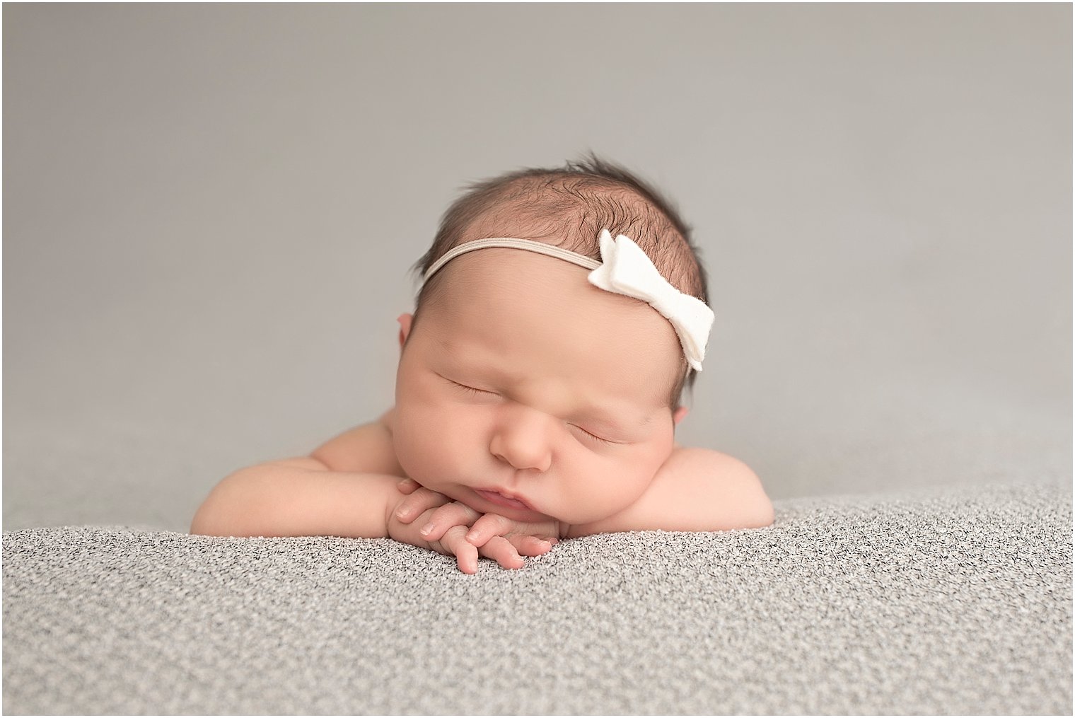 Newborn girl with white bow