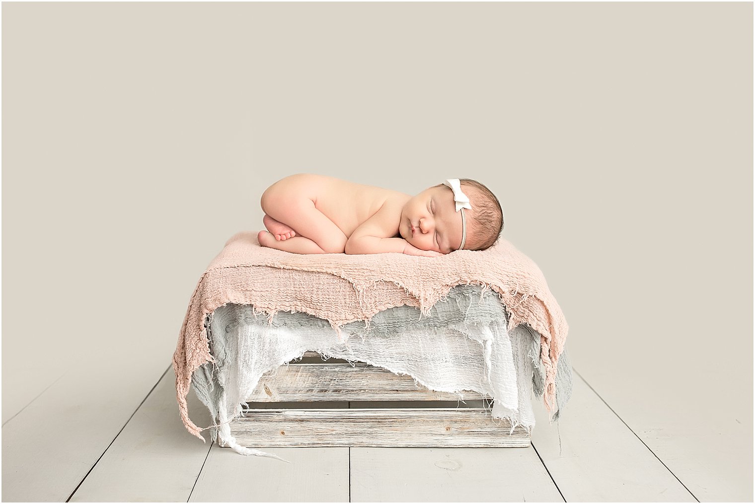 Newborn baby girl on rustic crate