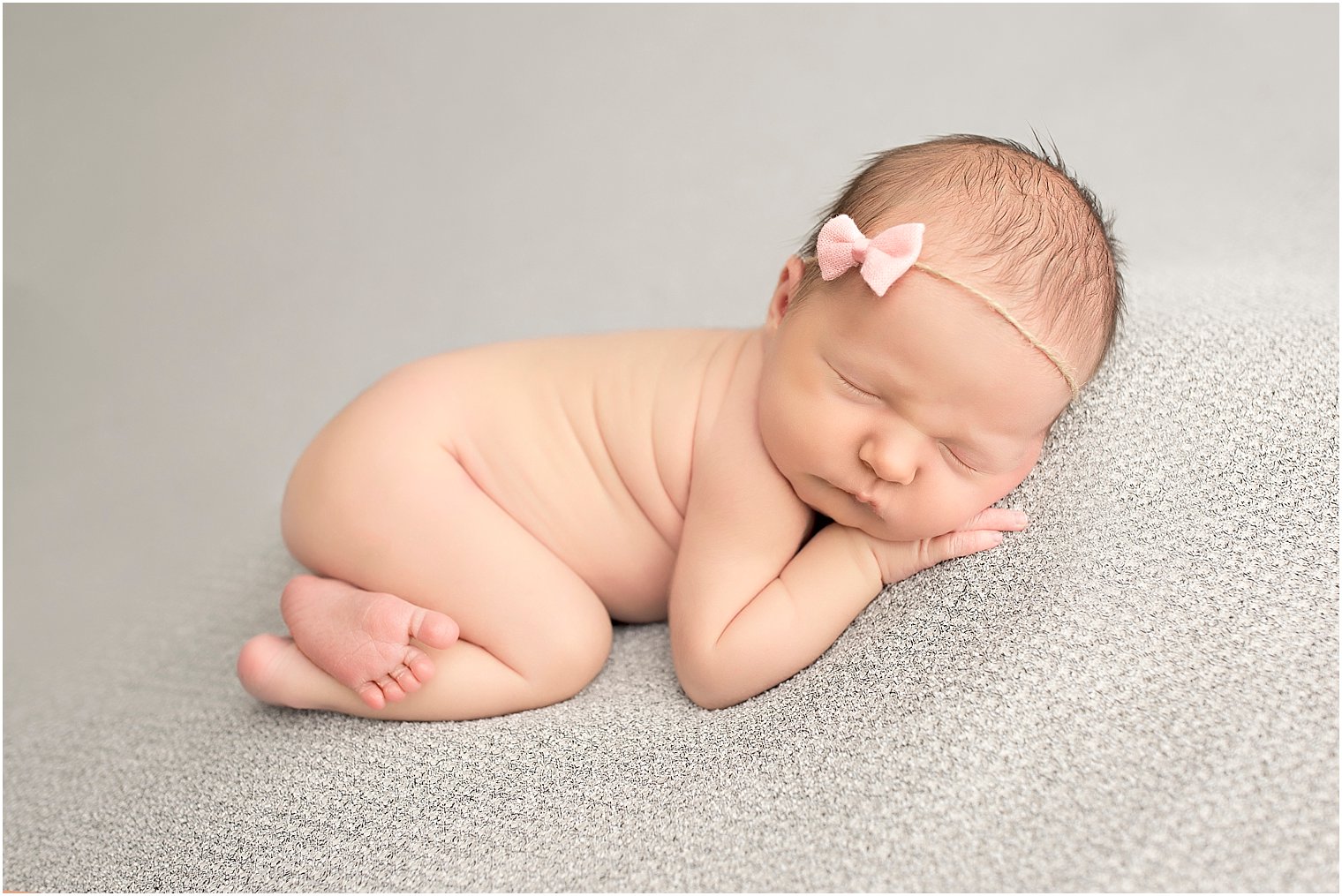 Newborn girl with pink bow