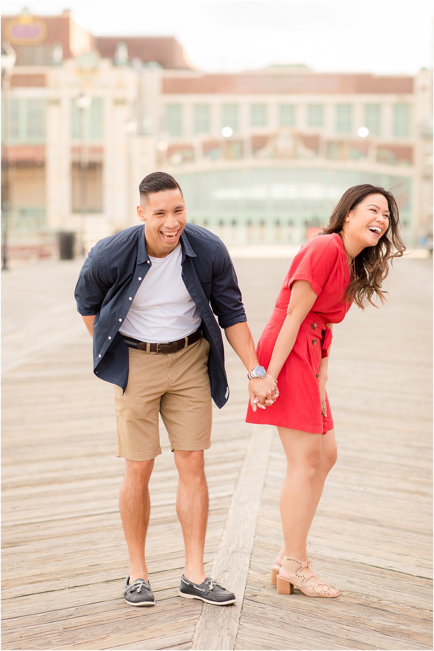 Couple laughing during engagement session in Asbury Park