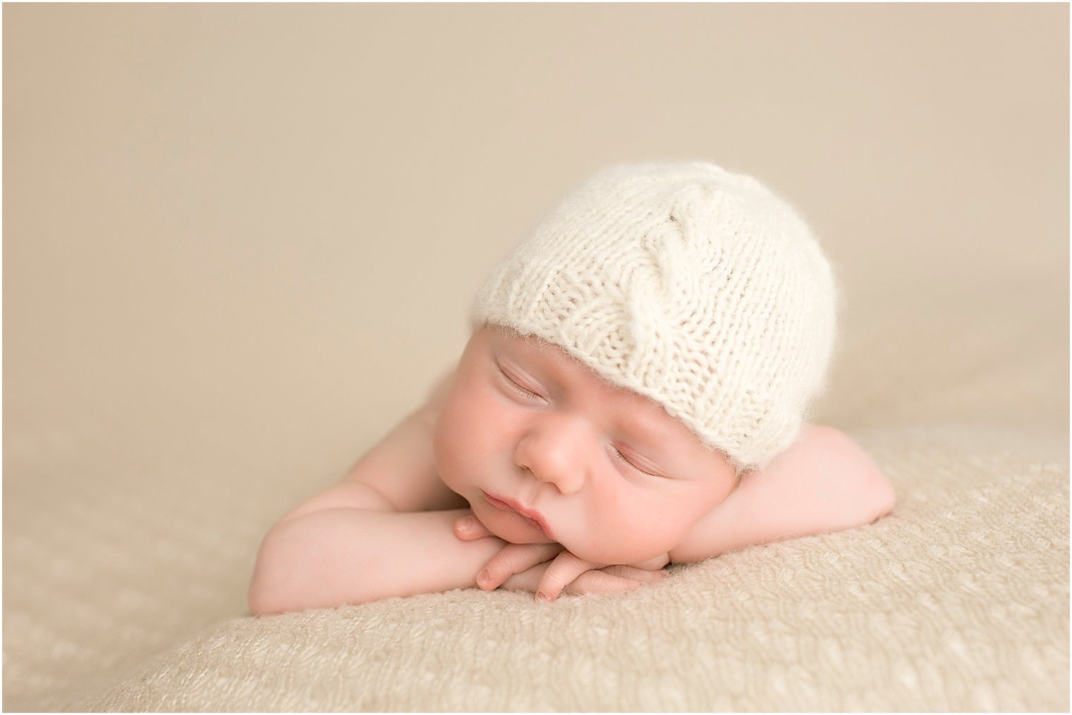 Newborn boy on beige blanket