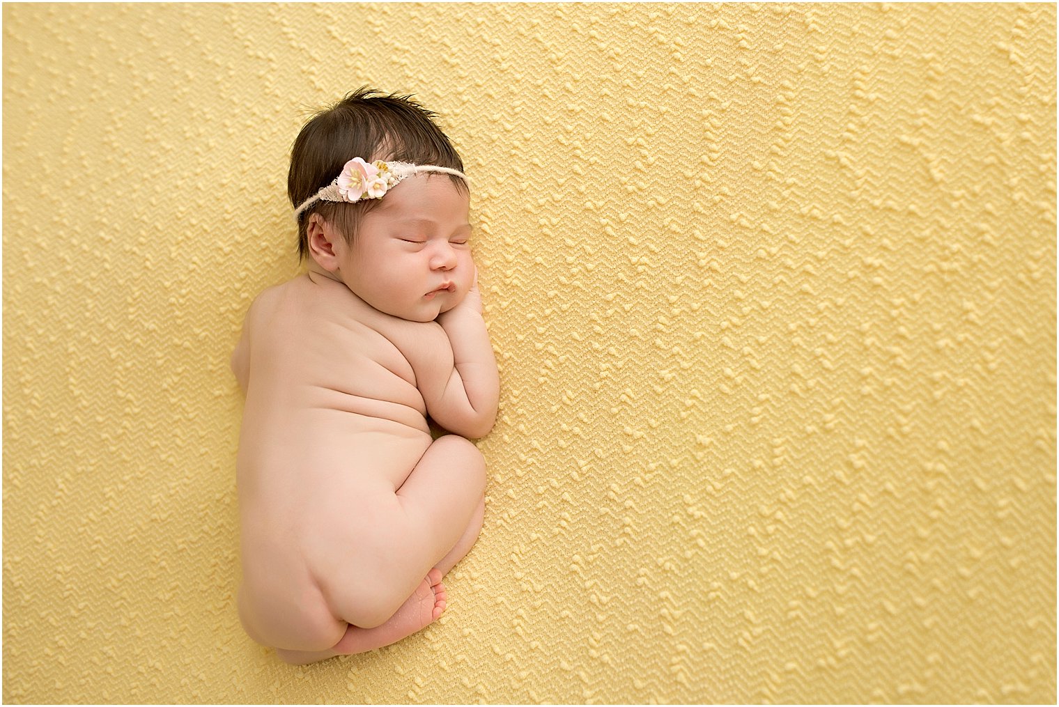 Newborn girl on yellow blanket