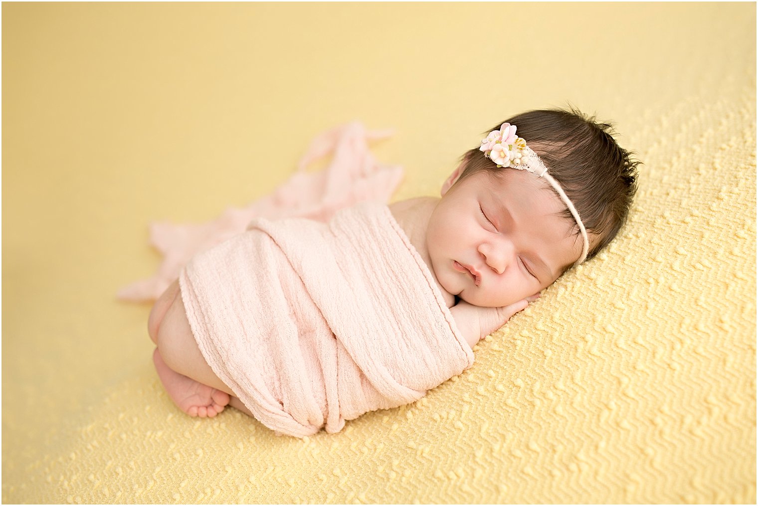 Newborn girl on yellow blanket