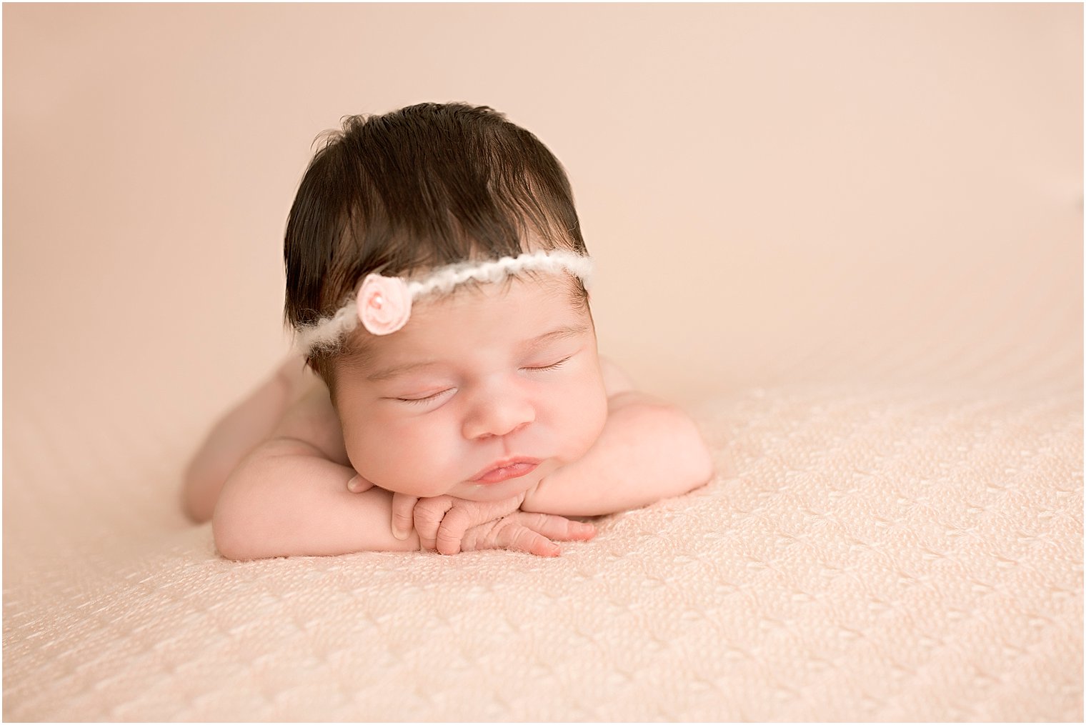 Baby girl with chin on hands