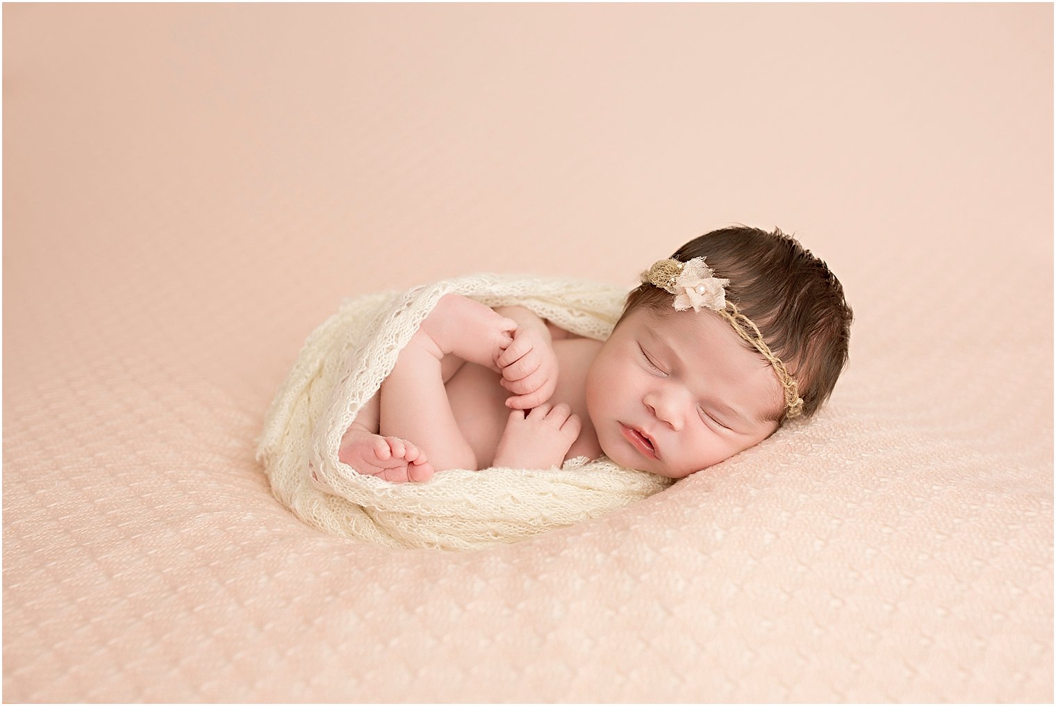 Newborn girl in pink and cream