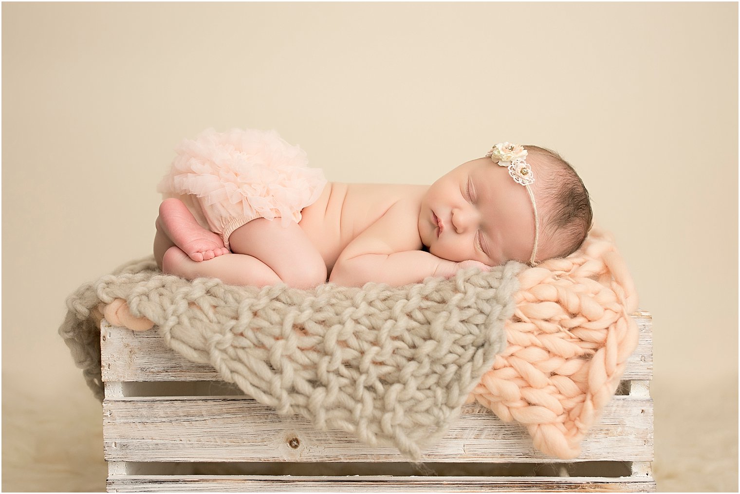 Newborn girl in peach and cream