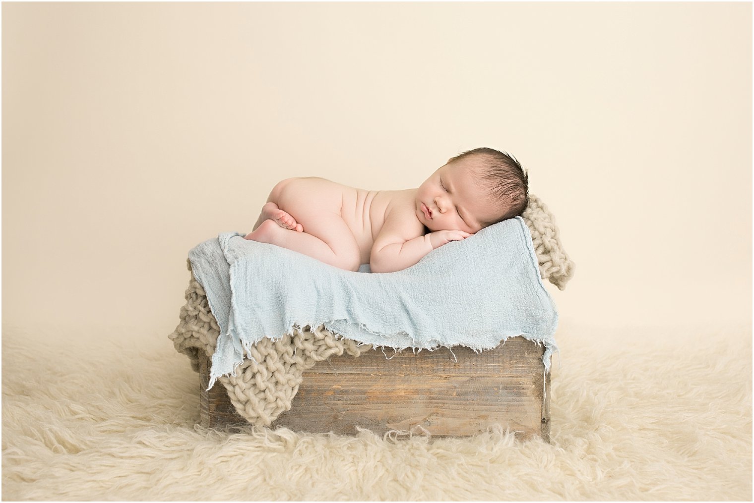 Newborn boy on crate