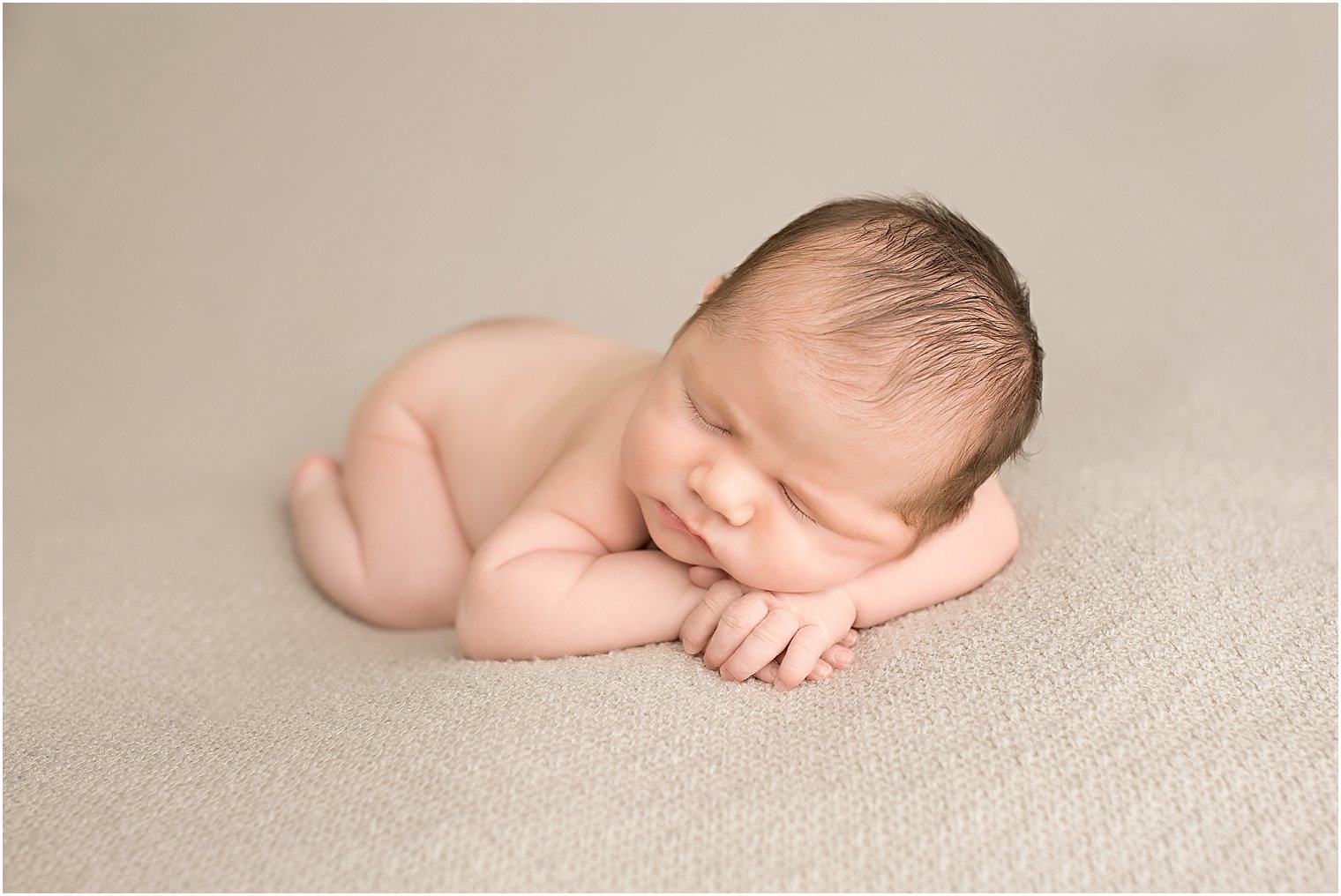 Baby boy in chin on hands pose