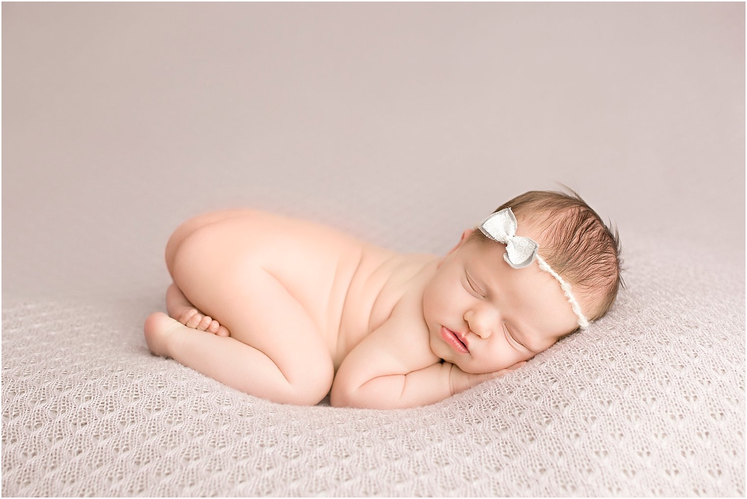 Newborn baby girl in tushie up pose