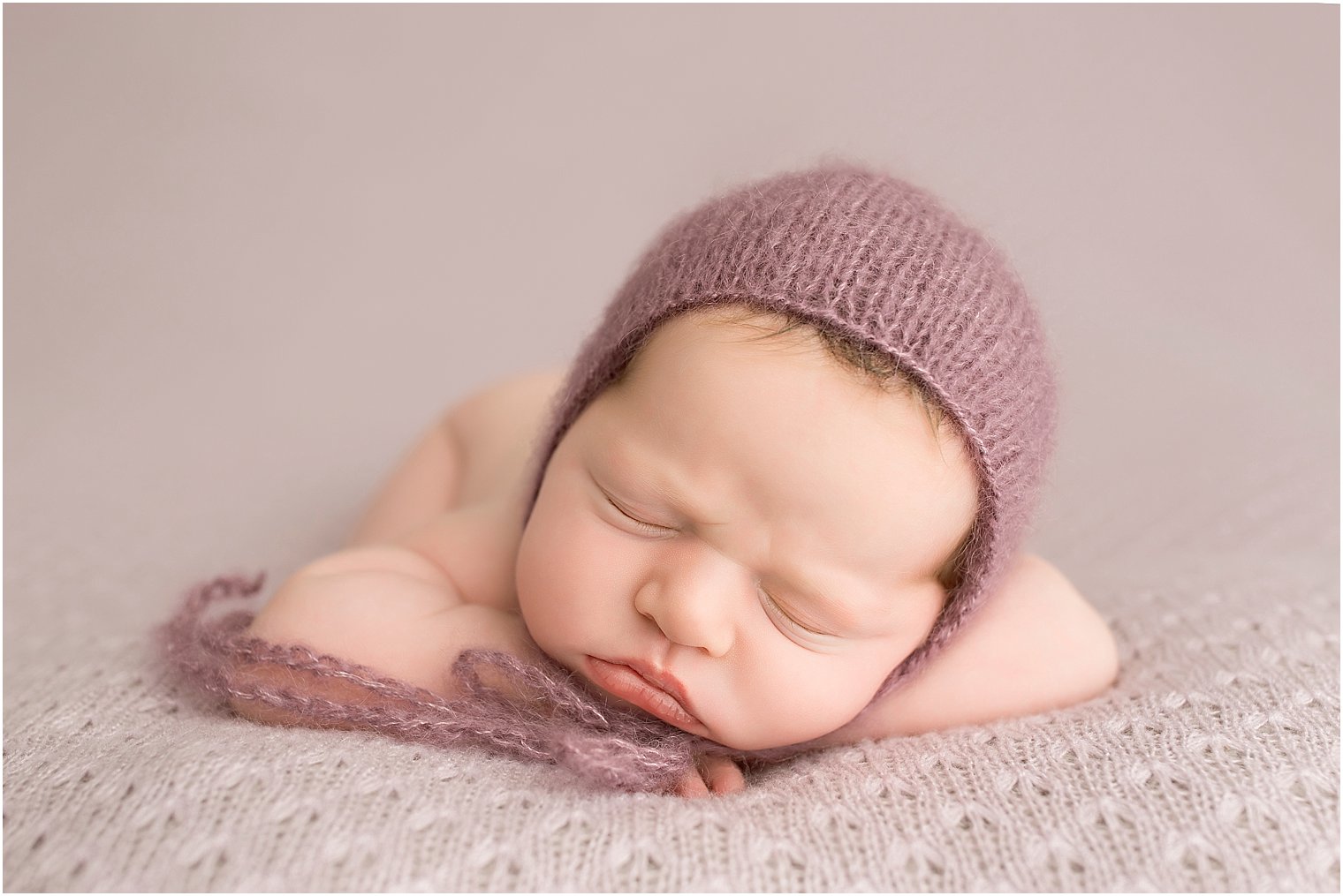 Newborn girl in chin on hands phose