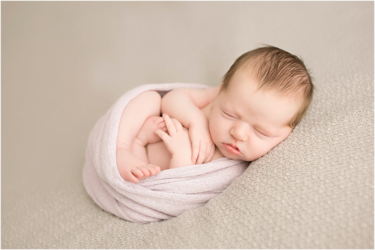 Newborn girl in purple wrap