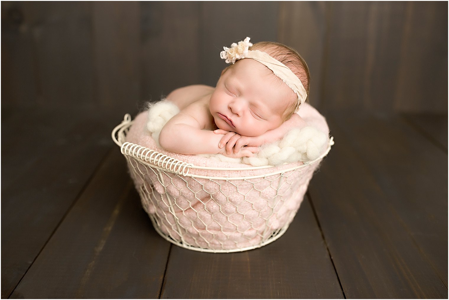 Newborn baby in a cream basket