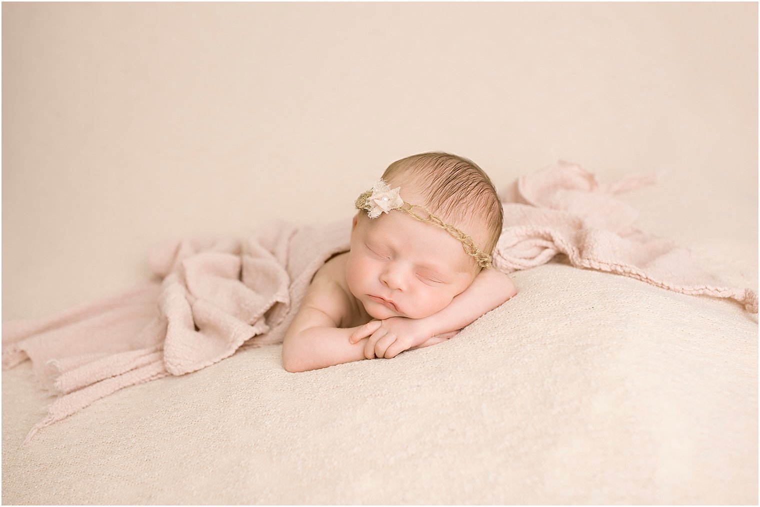 Newborn girl in pink and cream