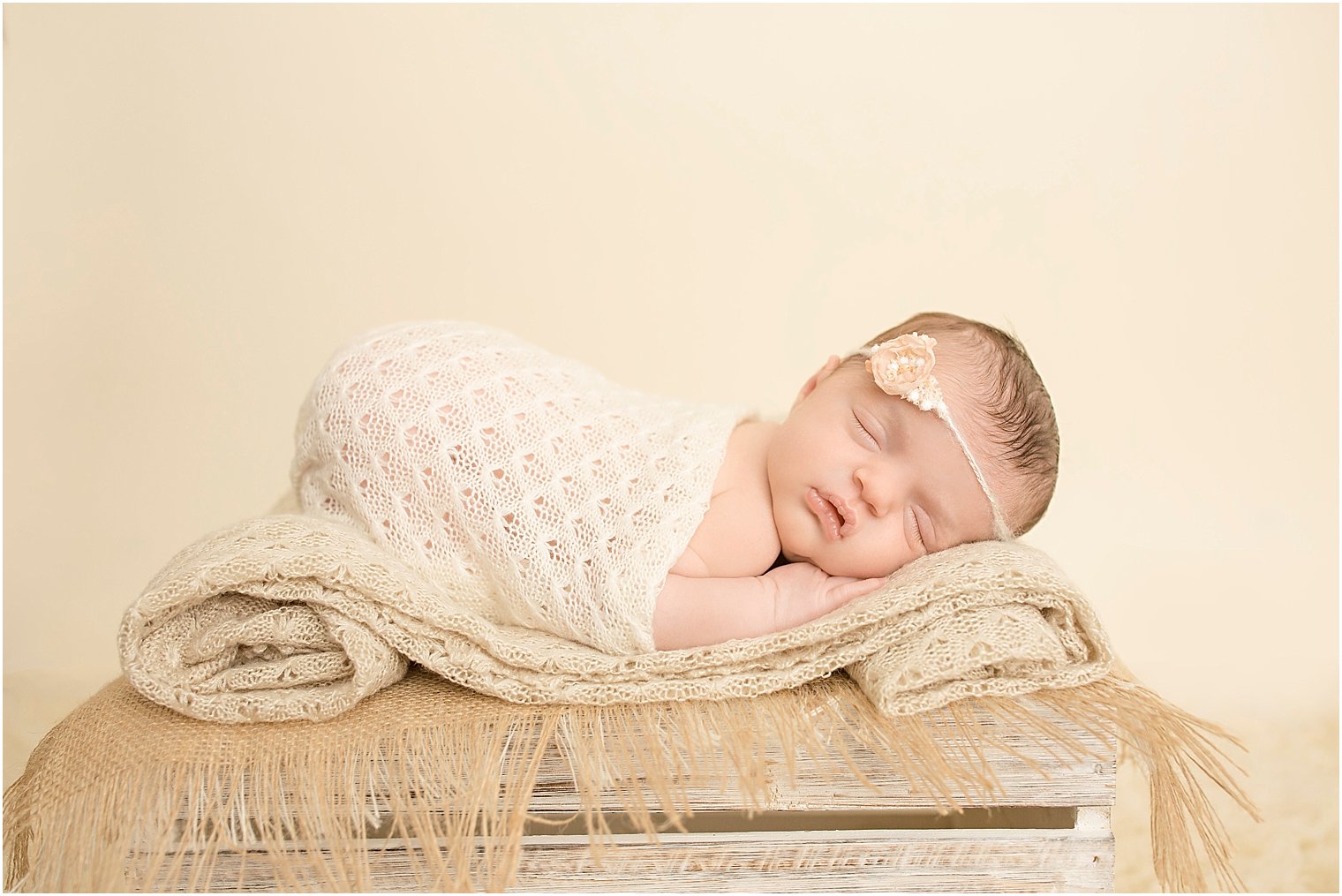 Newborn girl sleeping on a crate