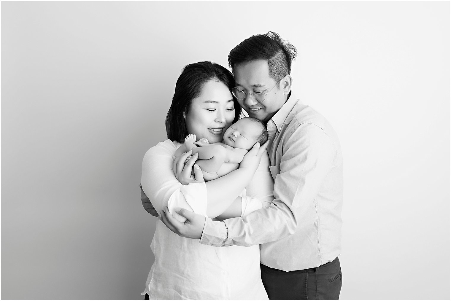 Black and white image of parents holding their new baby
