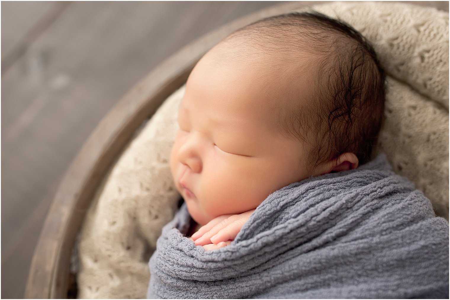 Newborn boy sleeping in bucket