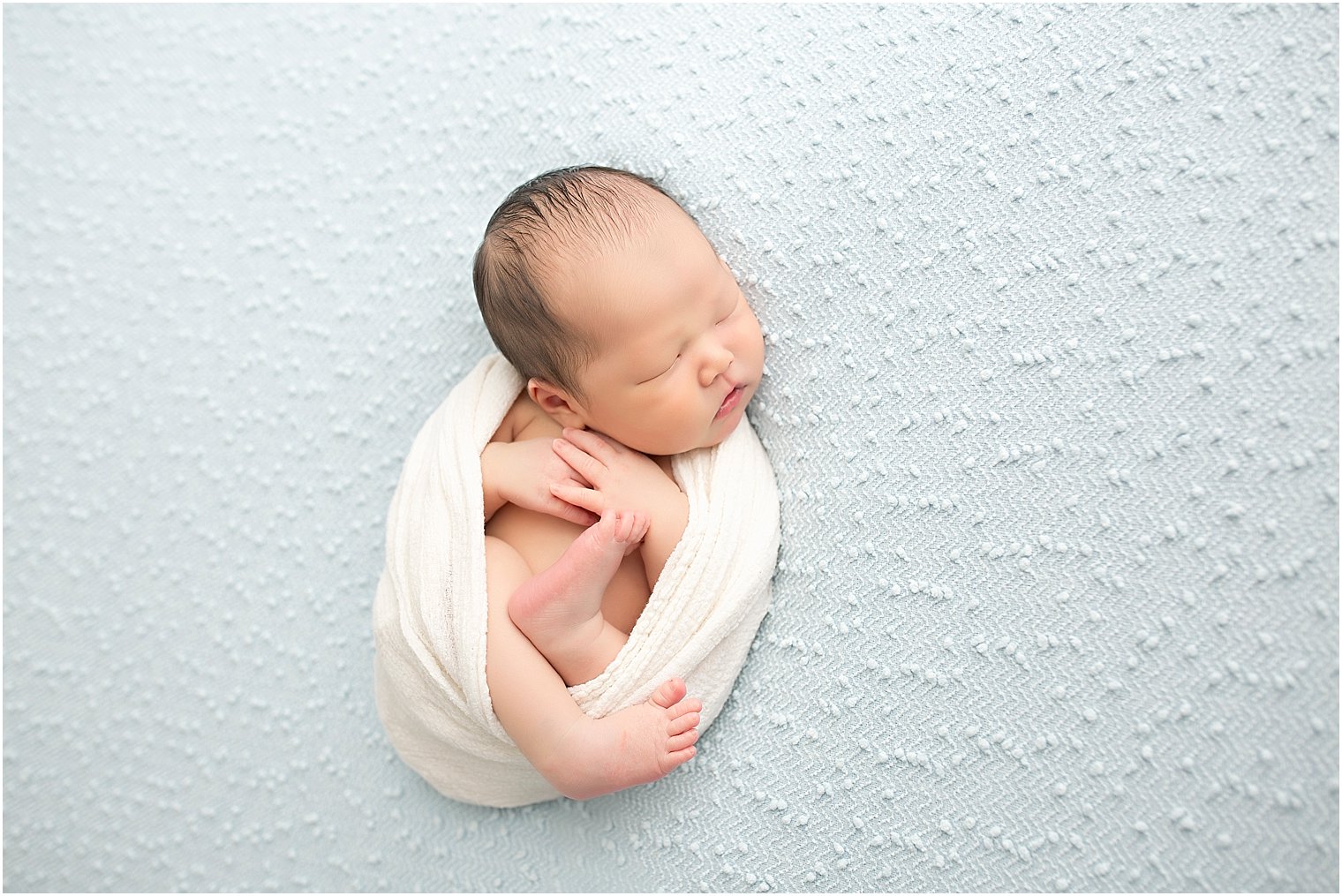 Newborn boy wrapped in cheesecloth