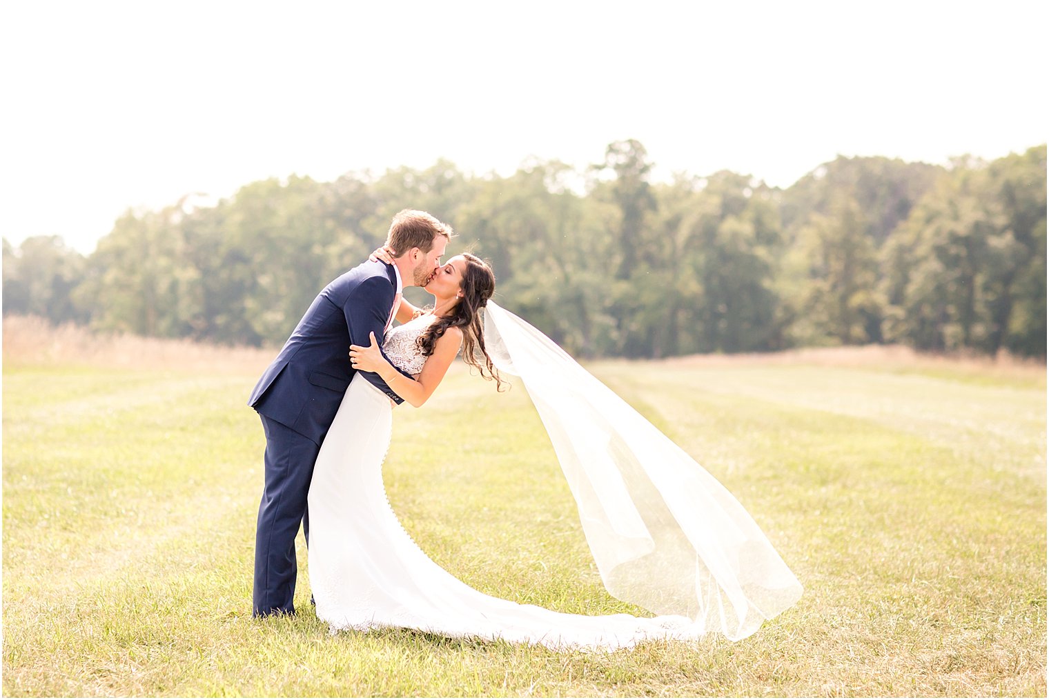 Wedding portrait of bride and groom in a large field | Photo by Idalia Photography