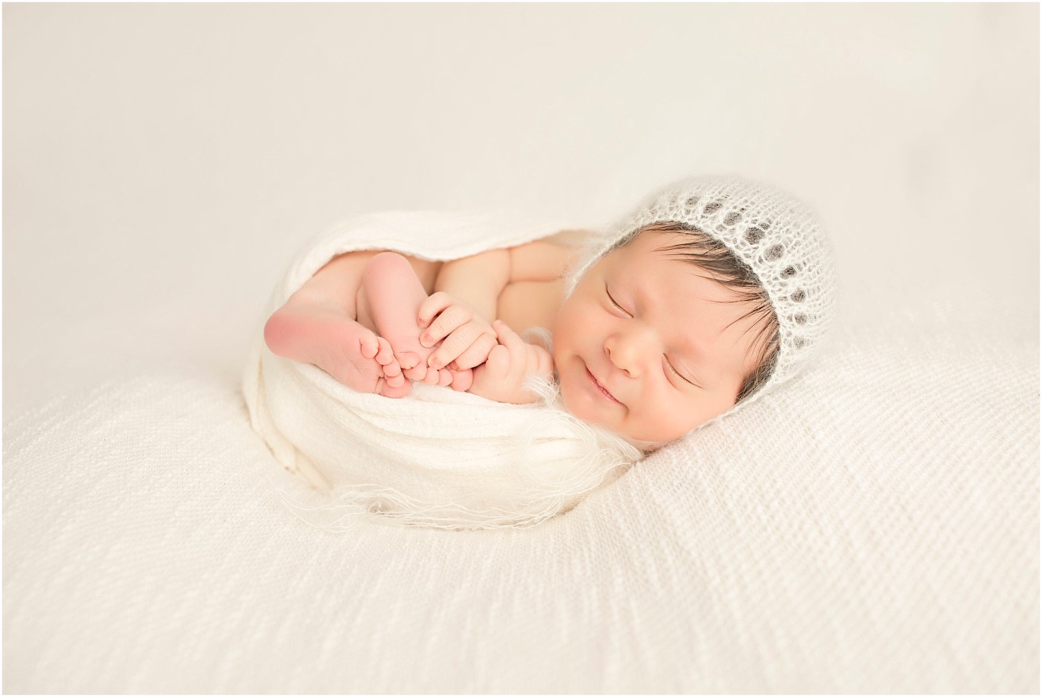 Baby boy in cream bonnet and blanket