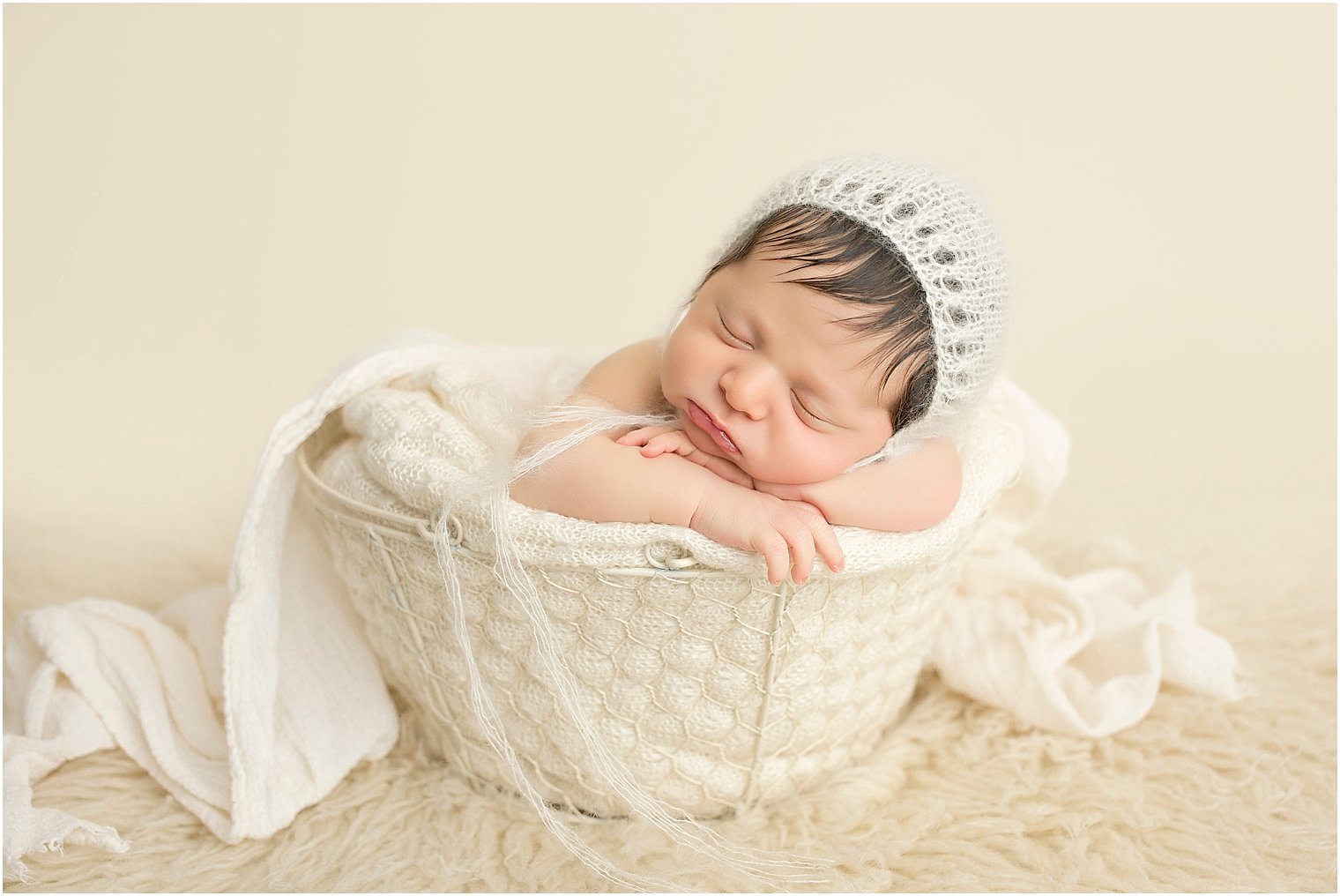 Newborn boy wearing a knit mohair cream bonnet