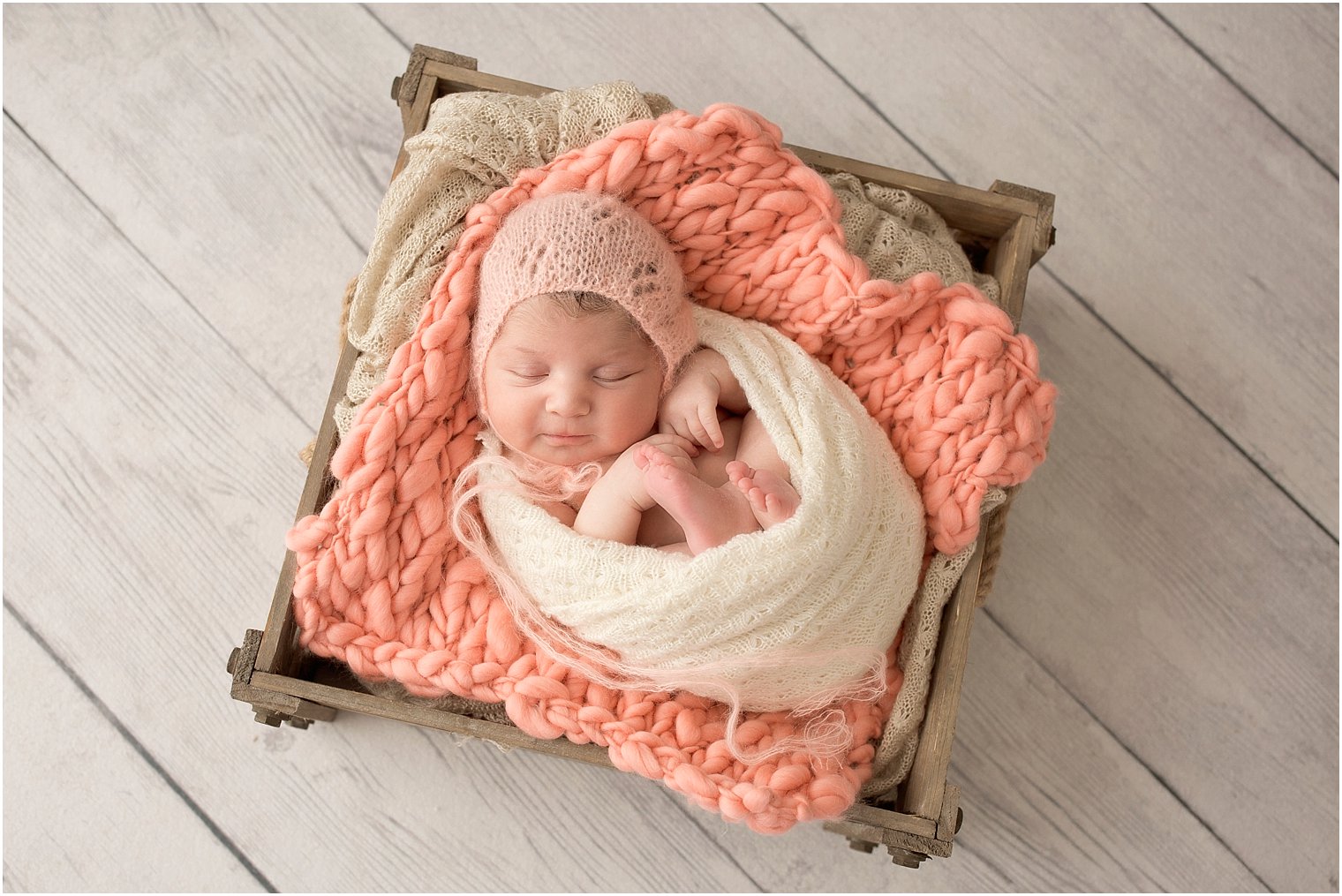 Newborn girl in mohair hat and peach layering blanket