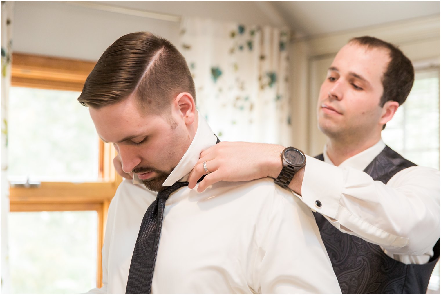 Best man helping groom get dressed